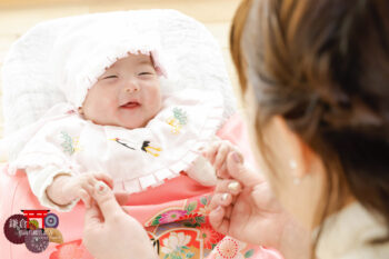 ほほえむ赤ちゃんとママの後ろ姿 お宮参りの記念写真撮影